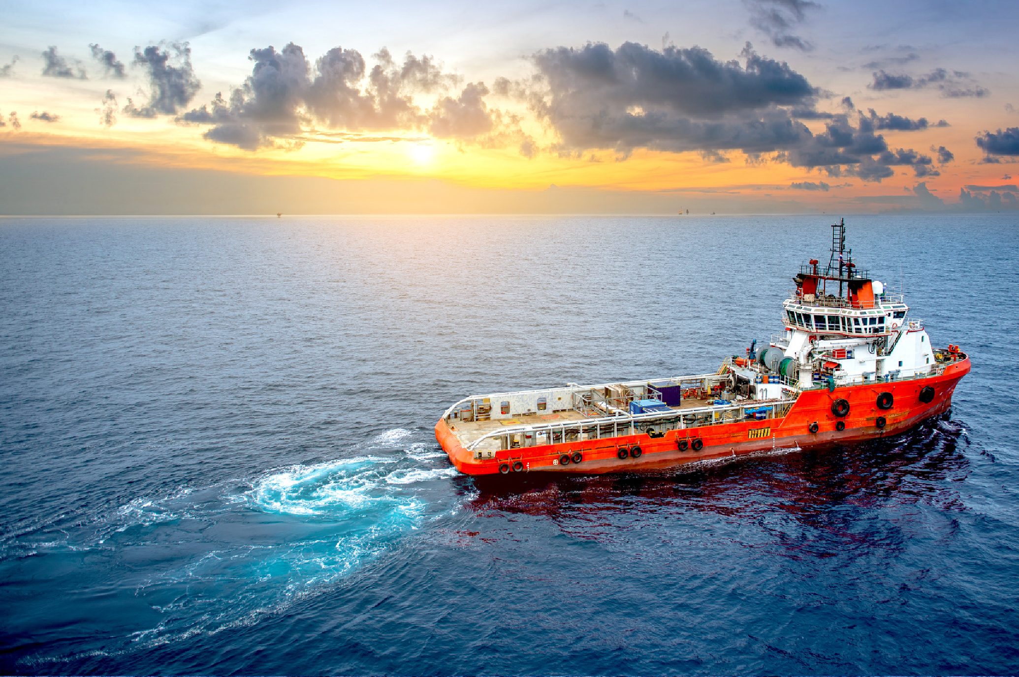 Marine vessel offshore at sunset